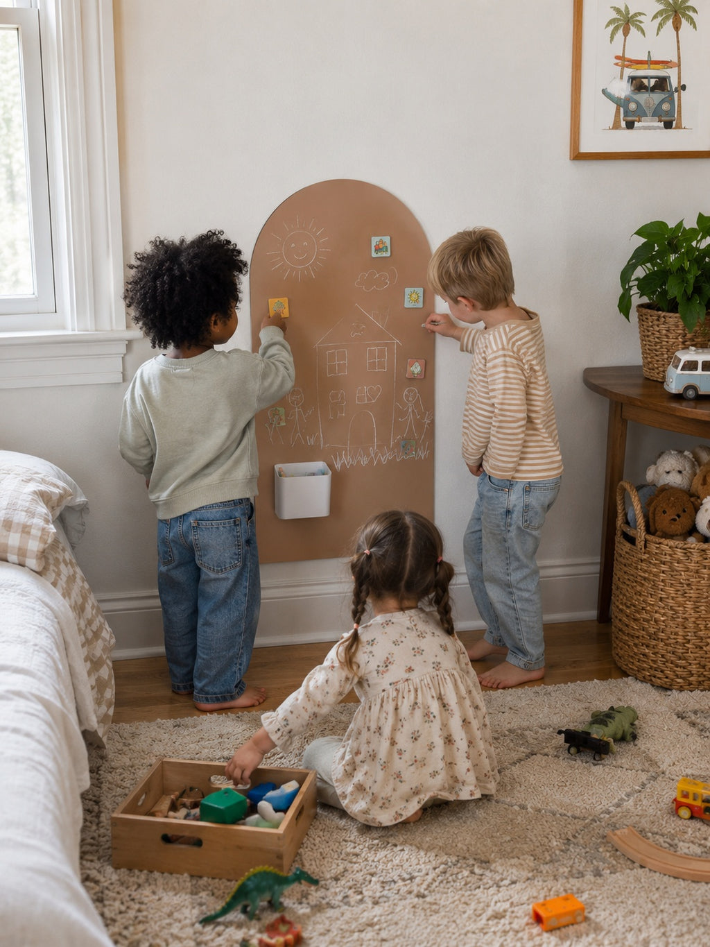 Three children play in a cozy child's room, interacting with a large arch-shaped wooden magnetic board on the wall. One child is writing on the board, while the other two look on and play with toys on the rug.